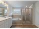 Bathroom featuring double sink vanity, bathtub, and glass enclosed shower at 3546 Sorrel Ln, Duluth, GA 30096