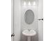 Stylish powder room featuring a pedestal sink, oval mirror, and modern lighting at 3546 Sorrel Ln, Duluth, GA 30096