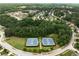 Aerial view featuring tennis courts nestled among a wooded residential area at 7628 Summer Berry Ln, Lithonia, GA 30038