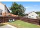 A cozy fenced backyard with green grass and outdoor seating at 7628 Summer Berry Ln, Lithonia, GA 30038