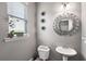 Well-lit bathroom features a pedestal sink, decorative mirror, and modern fixtures at 7628 Summer Berry Ln, Lithonia, GA 30038