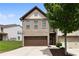 Charming two-story brick home with a two-car garage, a well-kept lawn, and a beautiful tree at 7628 Summer Berry Ln, Lithonia, GA 30038