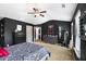 Spacious main bedroom featuring dark accent walls, a ceiling fan, and neutral carpeting at 7628 Summer Berry Ln, Lithonia, GA 30038