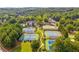 Aerial view of the community showing the club house, tennis courts, pool, and surrounding woods at 809 Hillcrest Ln, Woodstock, GA 30189