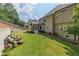 Large grassy backyard with a tiered retaining wall and patio seating at 809 Hillcrest Ln, Woodstock, GA 30189