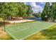 Outdoor basketball court and sand volleyball surrounded by mature trees at 809 Hillcrest Ln, Woodstock, GA 30189