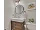 Chic half bathroom with a modern vanity, round mirror, and decorative art at 809 Hillcrest Ln, Woodstock, GA 30189