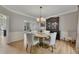 Dining room featuring hardwood floors, modern chandelier, and french door entry to living room at 809 Hillcrest Ln, Woodstock, GA 30189