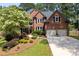 Charming brick home with a lush landscaped front yard and a two-car garage at 809 Hillcrest Ln, Woodstock, GA 30189