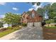 Brick home with a two-car garage and an expansive driveway, surrounded by mature trees at 809 Hillcrest Ln, Woodstock, GA 30189