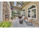 Cozy outdoor covered patio with stone fireplace and arched windows at 809 Hillcrest Ln, Woodstock, GA 30189