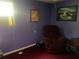 View of purple bedroom containing red carpet, chair, window AC unit, and a painting at 10199 Starr Sw St, Covington, GA 30014