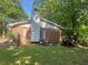 Back exterior view of a red brick home with a white chimney and small wooden deck at 10199 Starr Sw St, Covington, GA 30014