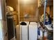 Picture of an older laundry room and storage area with a hot water heater and outdated machines at 10199 Starr Sw St, Covington, GA 30014