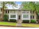 Charming brick building featuring symmetrical design, white trim, balconies, and lush greenery in a serene neighborhood setting at 1879 Johnson Ne Rd # 10, Atlanta, GA 30306