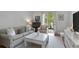 Bright living room with white walls, hardwood floors, a stylish sofa, and French doors that amplify the natural light at 1879 Johnson Ne Rd # 10, Atlanta, GA 30306