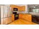 Well-lit kitchen featuring stainless steel refrigerator, black range, and light wood cabinets at 2104 Meadow Peak Rd, Duluth, GA 30097