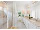 A full bathroom features a glass-enclosed shower and double vanity with white cabinets and granite counters at 230 Fender Walk, Marietta, GA 30060
