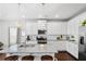 Bright kitchen features a granite island, stainless steel appliances, and white cabinets at 230 Fender Walk, Marietta, GA 30060
