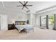 This spacious main bedroom features a tray ceiling, fan, a gray bed frame and an exterior door to a porch at 230 Fender Walk, Marietta, GA 30060