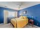Bedroom with blue walls, natural lighting, bed with yellow comforter, and dark dresser at 1705 Monroe Ne Dr # D05, Atlanta, GA 30324