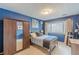 Comfortable bedroom with a large window, wardrobe, neutral carpet, and blue walls at 1705 Monroe Ne Dr # D05, Atlanta, GA 30324