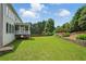 Well-manicured backyard with lush lawn, mature trees, retaining wall, and a charming pergola at 2802 Arabian Ne Trl, Marietta, GA 30062