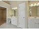 Bathroom with dual sinks, mirrors, white cabinets, tile floors, and entry to a walk-in closet at 2802 Arabian Ne Trl, Marietta, GA 30062