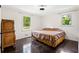 This bedroom features dark hardwood floors, two bright windows, and simple neutral paint at 2905 Jim Owens Nw Rd, Kennesaw, GA 30152