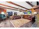 Spacious living room with exposed wood beams, wood paneling and a decorative area rug at 2905 Jim Owens Nw Rd, Kennesaw, GA 30152