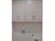White cabinets provide ample storage space above the laundry area at 297 White St # 1, Marietta, GA 30060