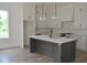 Contemporary kitchen with a gray island, white cabinets, and modern stainless steel appliances at 297 White St # 1, Marietta, GA 30060