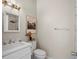 Bathroom featuring a white vanity with a sink and a framed mirror, toilet and decorative painting at 20 Marietta Nw St # 15D, Atlanta, GA 30303