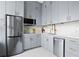 A modern kitchen with stainless steel appliances and grey cabinets with gold hardware accents at 20 Marietta Nw St # 15D, Atlanta, GA 30303