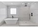 Luxurious bathroom with freestanding tub, large walk-in shower, and marble tile at 37 Deer Canyon Dr, Auburn, GA 30011
