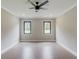 Bedroom with two windows offering wooded views and a ceiling fan with dark finish at 37 Deer Canyon Dr, Auburn, GA 30011