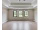 Bright bedroom with tray ceiling and three large windows overlooking the lush backyard at 37 Deer Canyon Dr, Auburn, GA 30011