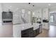 Spacious kitchen with white cabinetry, stainless appliances, an island with a marble countertop, and adjacent living area at 37 Deer Canyon Dr, Auburn, GA 30011