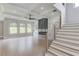 Open floorplan living room with a fire place, windows, hardwood flooring, and stair access at 37 Deer Canyon Dr, Auburn, GA 30011
