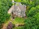 Back of home with patio, deck, and landscaping seen from above with mature trees at 9035 Brixham Ct, Suwanee, GA 30024