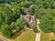 Aerial view of the home surrounded by mature trees and luscious green landscape at 9035 Brixham Ct, Suwanee, GA 30024