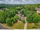 An aerial view of the house in its neighborhood with tree coverage at 9035 Brixham Ct, Suwanee, GA 30024