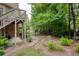 Backyard featuring a stone pathway leading to a wooded area with mature trees and greenery at 9035 Brixham Ct, Suwanee, GA 30024