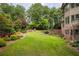 Spacious backyard with lush lawn, mature trees, and terraced landscaping for outdoor enjoyment at 9035 Brixham Ct, Suwanee, GA 30024