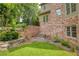 Landscaped backyard with brick retaining walls offering curb appeal to the exterior of this brick home at 9035 Brixham Ct, Suwanee, GA 30024