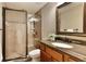 Modern bathroom features granite vanity, tile shower with glass door, and a decorative mirror at 9035 Brixham Ct, Suwanee, GA 30024