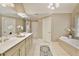 A luxurious bathroom featuring double sinks, a soaking tub, and neutral tones at 9035 Brixham Ct, Suwanee, GA 30024