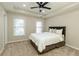 A cozy bedroom with a tray ceiling, ceiling fan, and neutral carpet at 9035 Brixham Ct, Suwanee, GA 30024