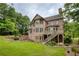 Beautiful brick home showcasing a spacious backyard, deck, and lush landscaping at 9035 Brixham Ct, Suwanee, GA 30024