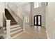 Grand foyer with a staircase, hardwood floors, and decorative glass double doors at 9035 Brixham Ct, Suwanee, GA 30024